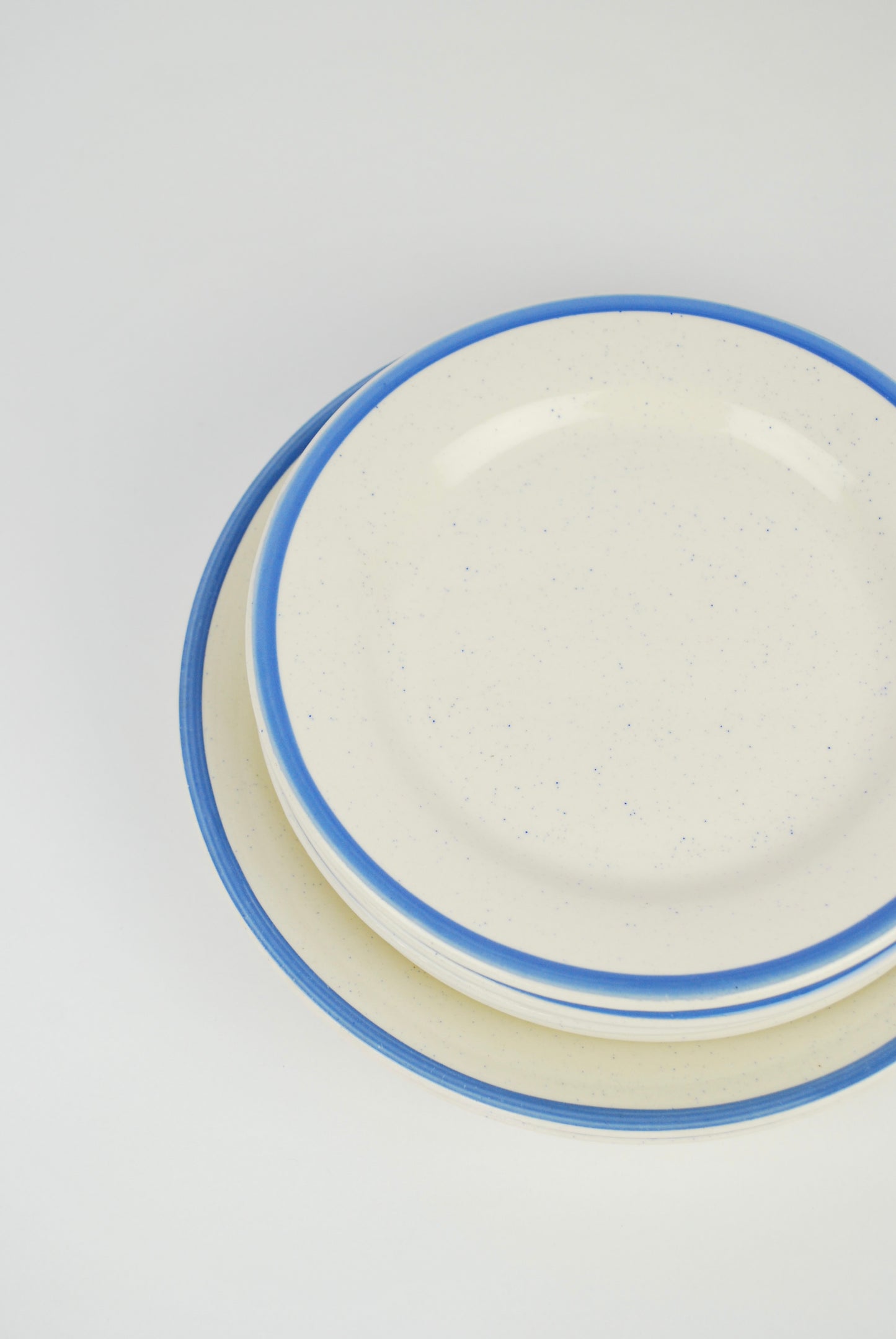 six white plates with blue rim and spots