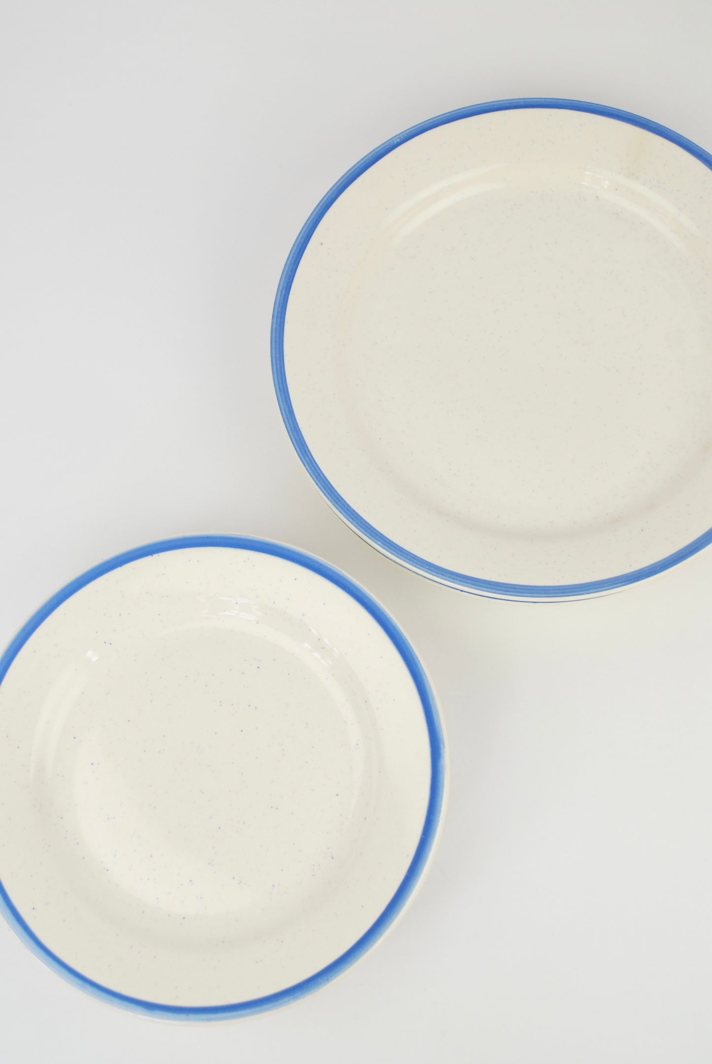 six white plates with blue rim and spots
