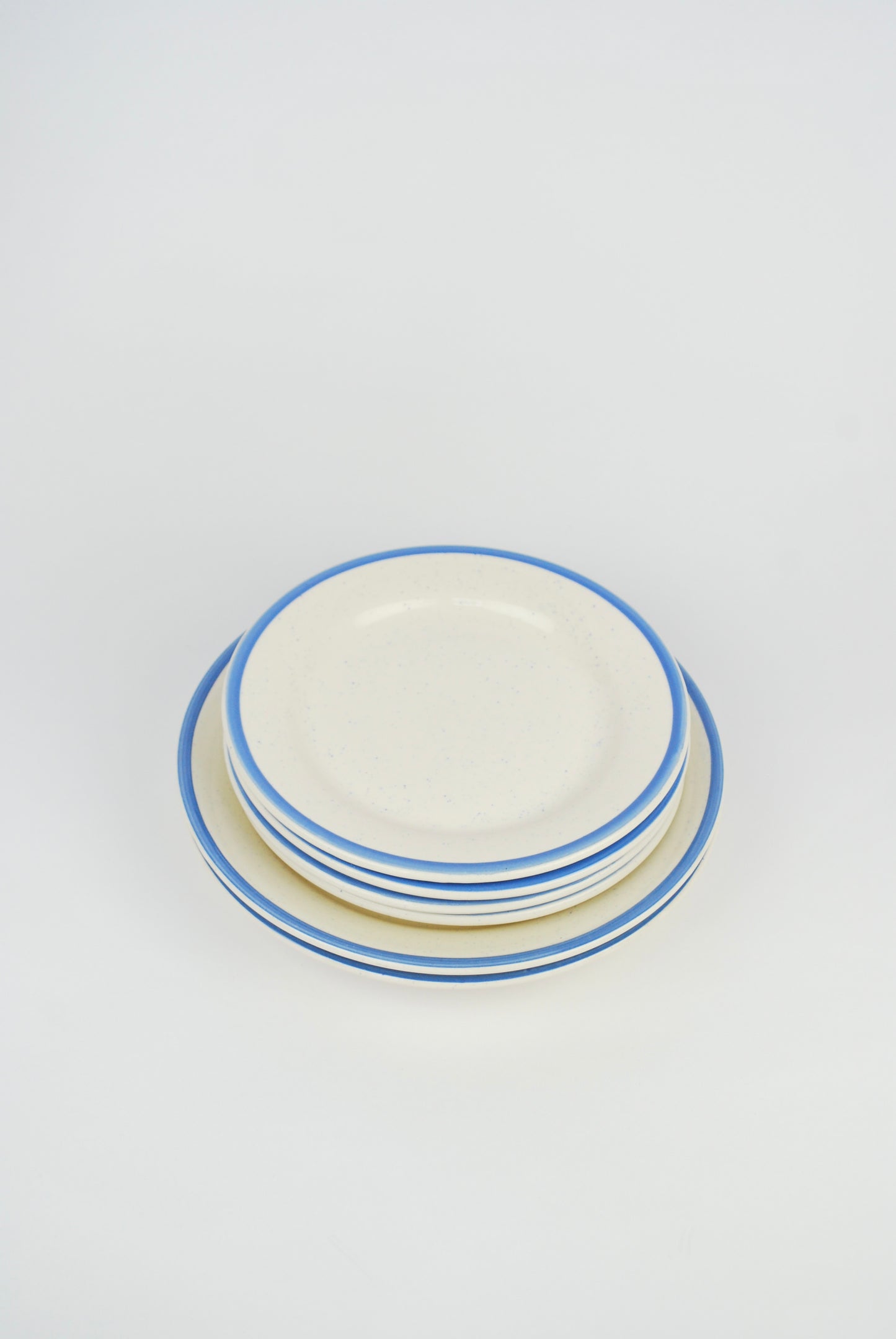 six white plates with blue rim and spots
