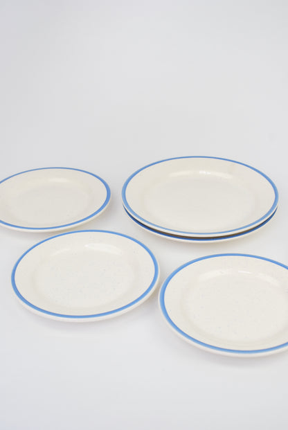 six white plates with blue rim and spots