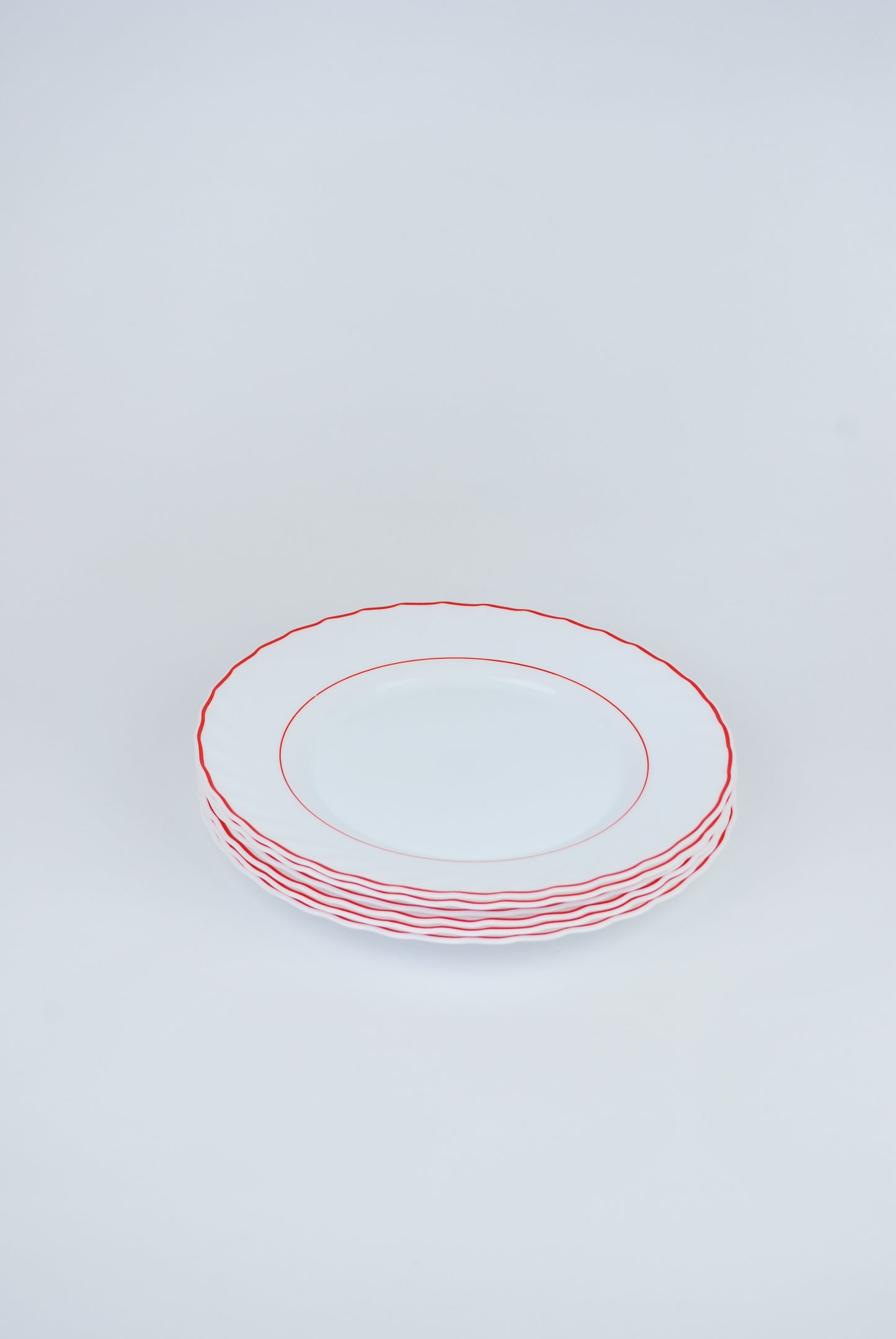 six white plates with red rim