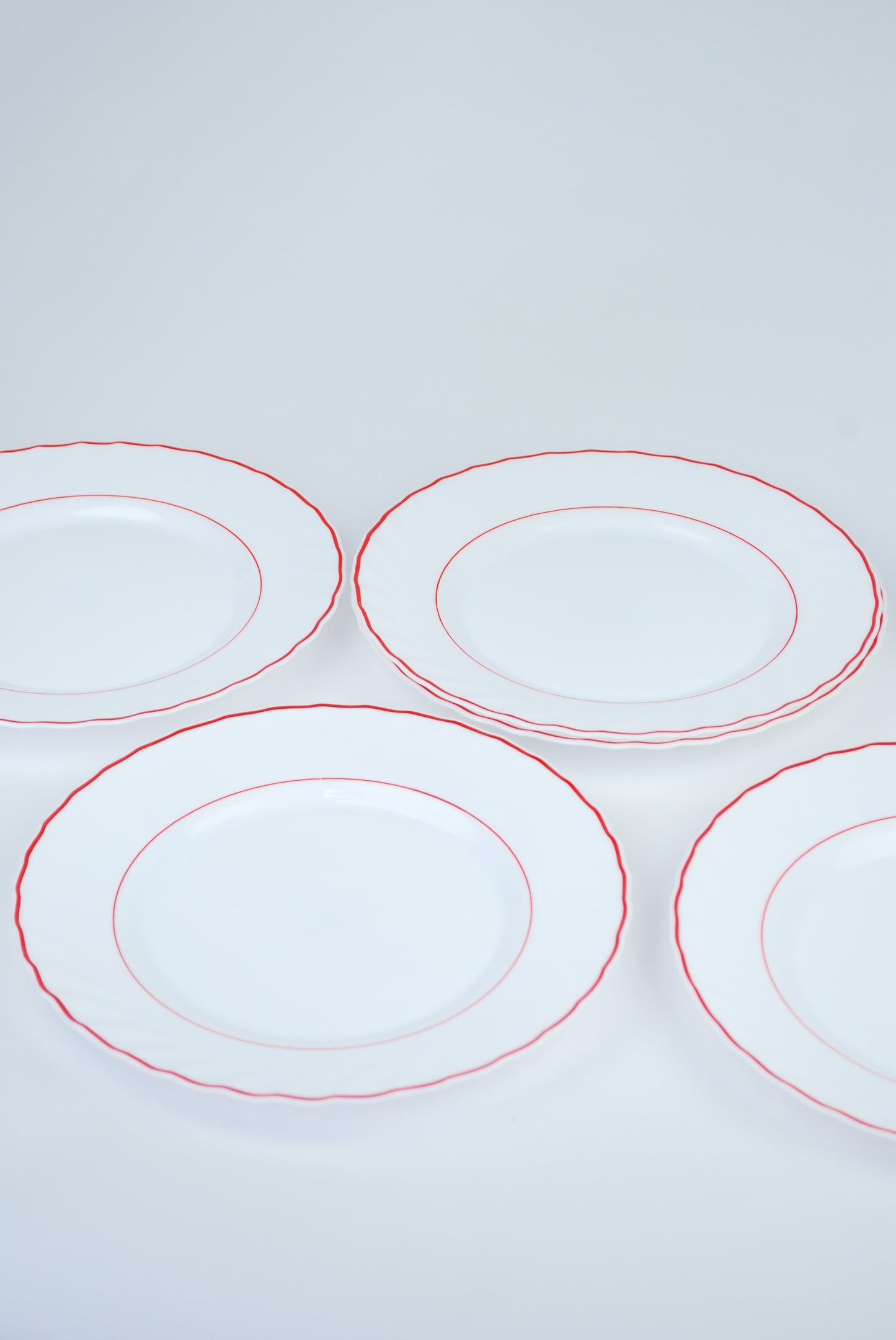 six white plates with red rim