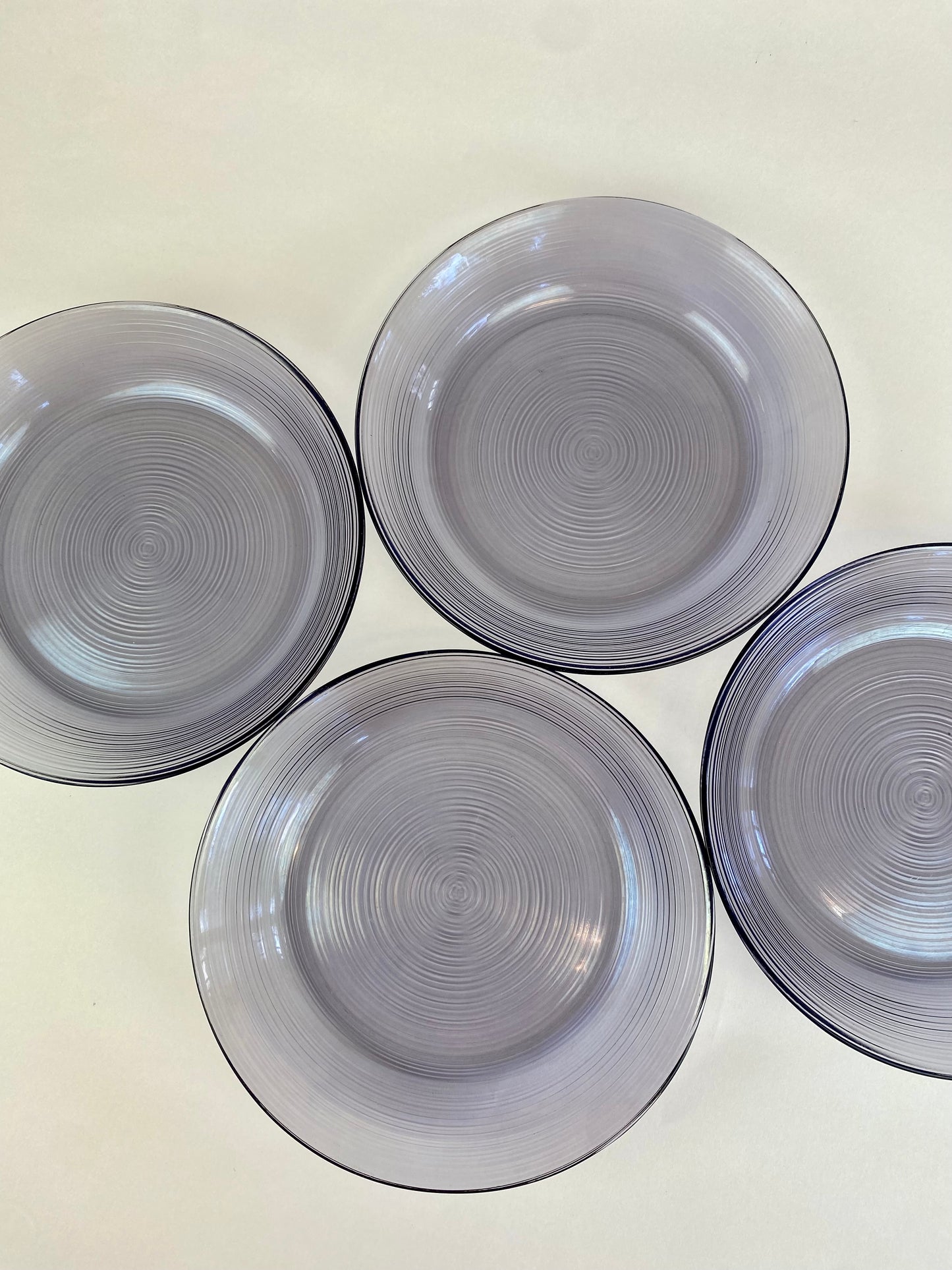 four purple glass plates