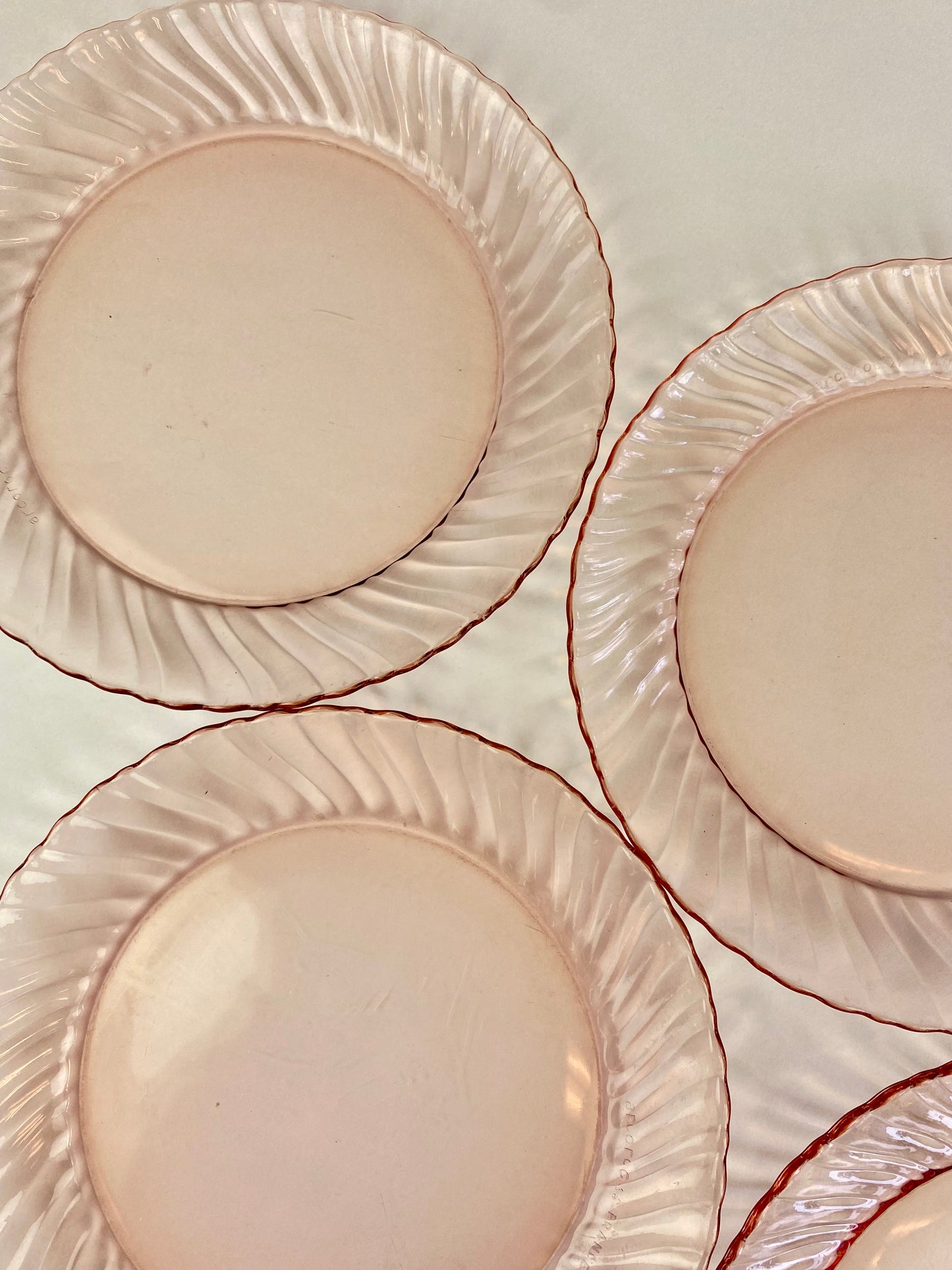 four pink glass plates