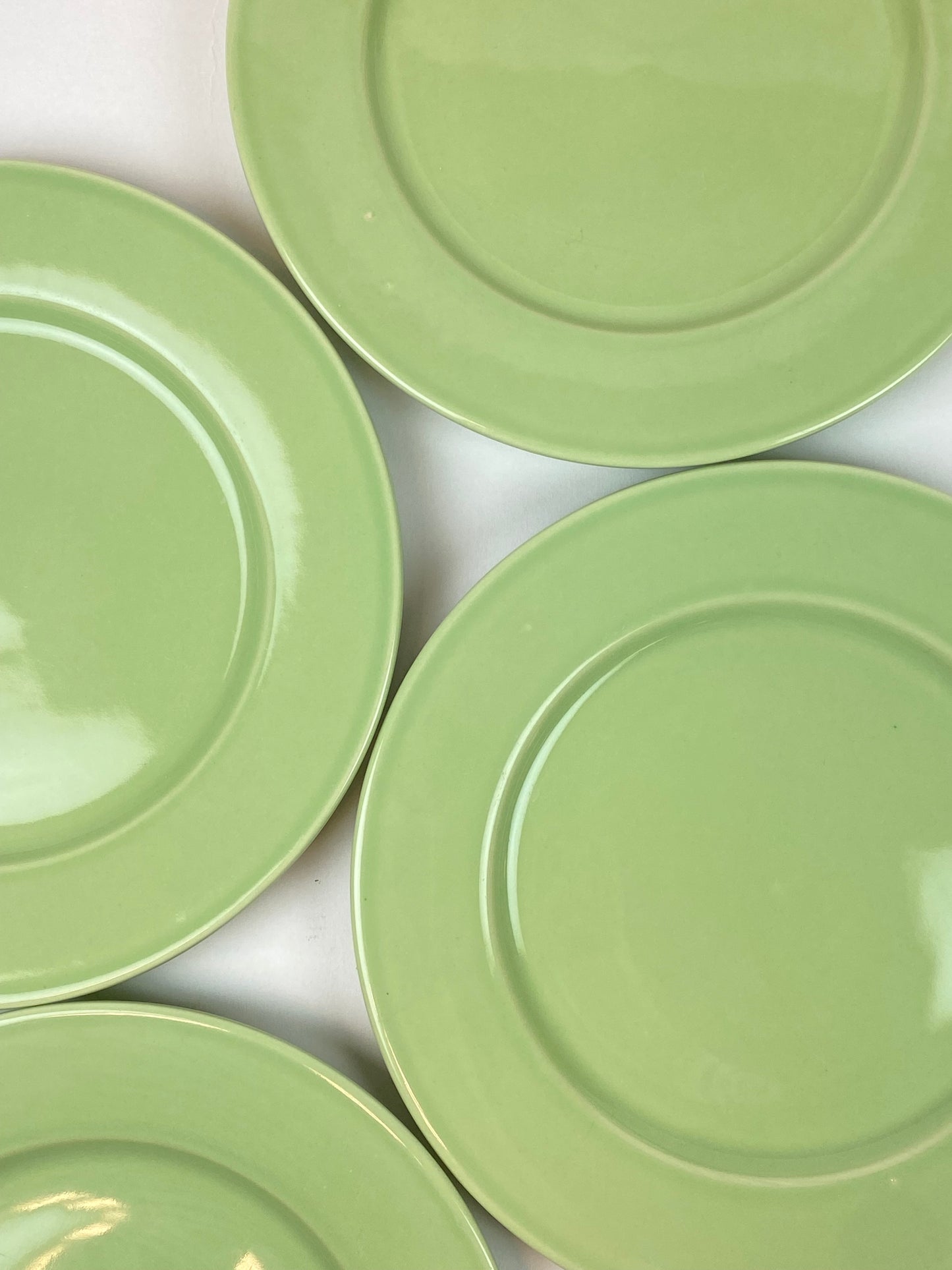 four pastel green plates