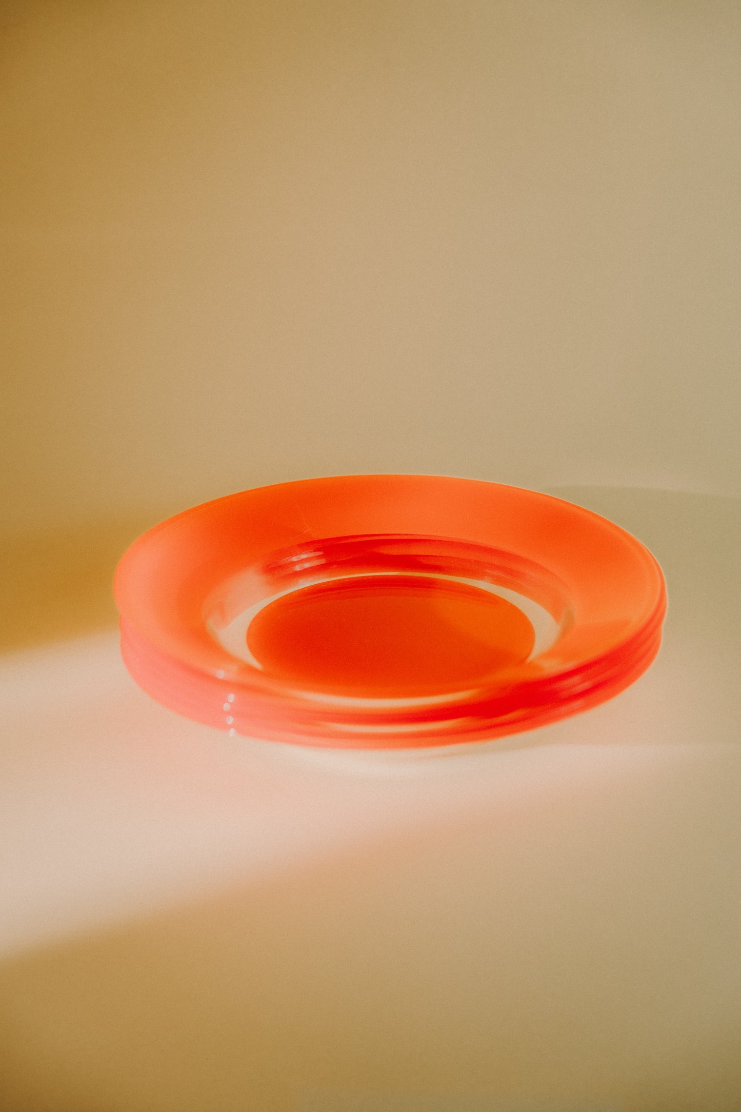 four orange glass plates