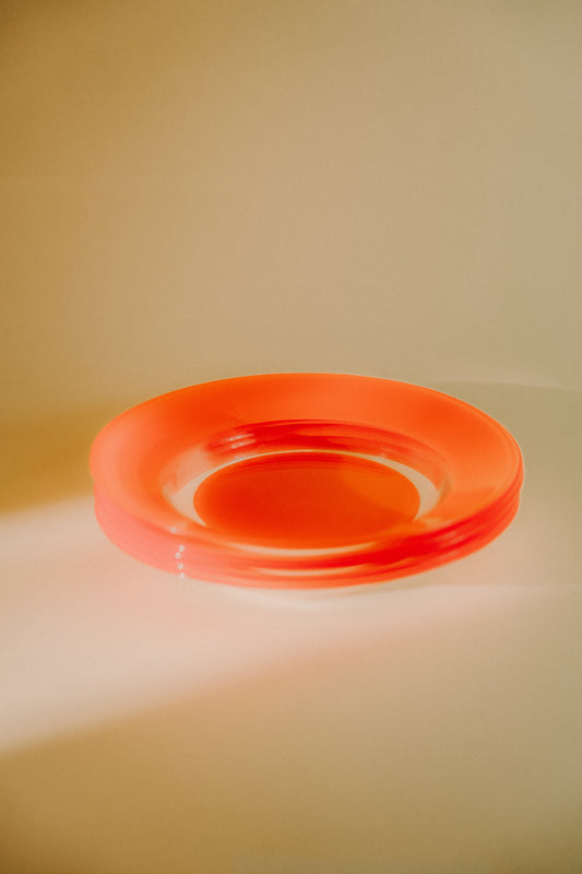 four orange glass plates