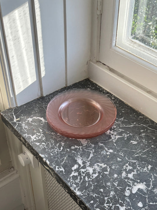 four pink glass plates