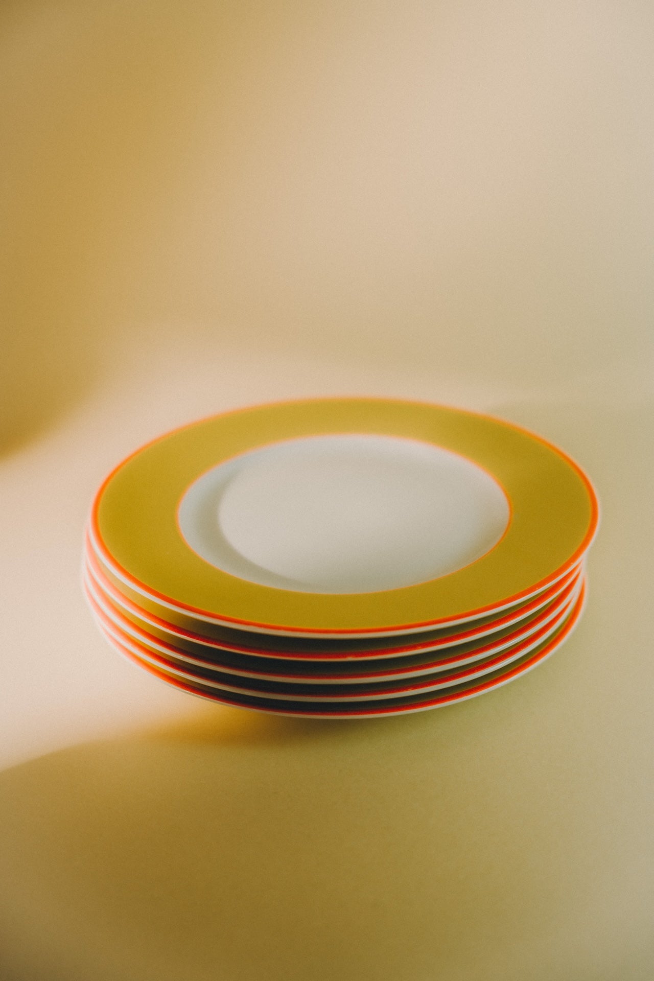 five plates with yellow rim